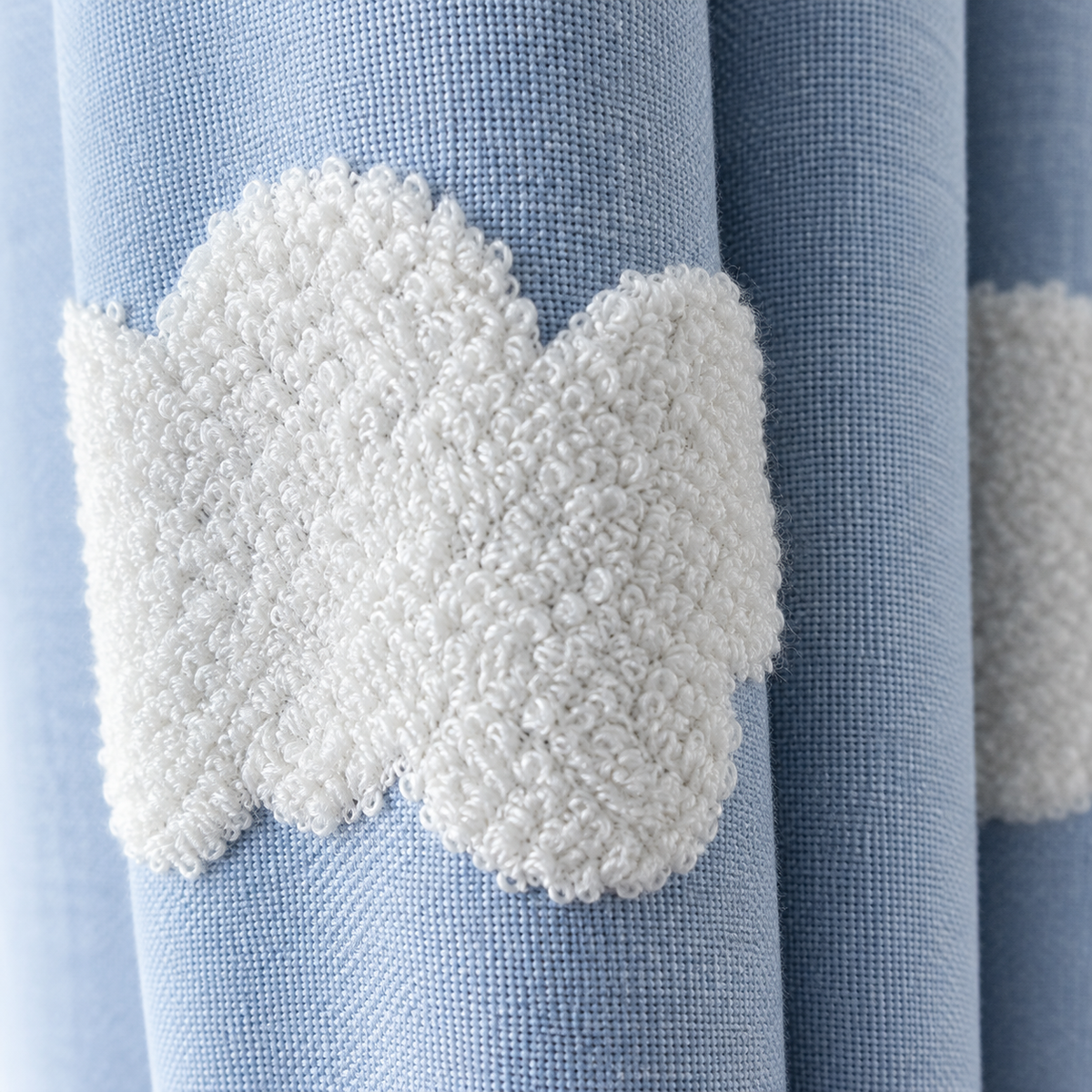 Rideau tamisant bleu doux à nuages brodés en relief – détail de la matière